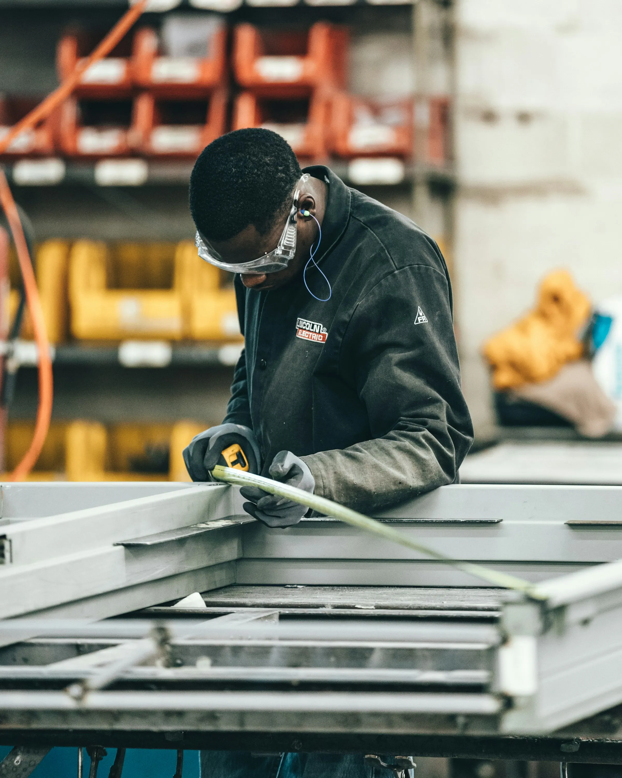 Operatore che misura un telaio metallico in officina
